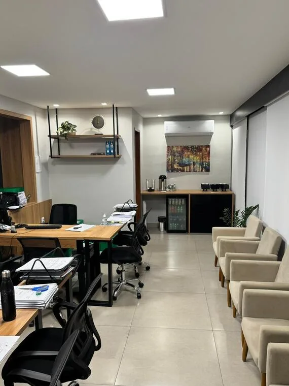 Sala de atendimento do cartório com mesas de trabalho, poltronas de espera e copa com bebidas