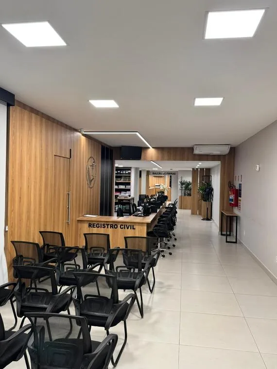Setor de Registro Civil do cartório com balcão de madeira e cadeiras para espera