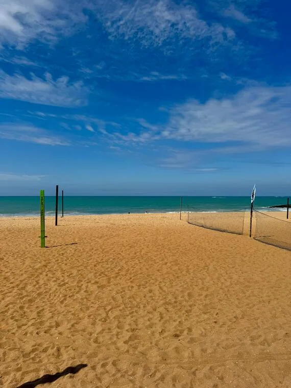 Areia dourada e rede de vôlei em praia tranquila de Rio das Ostras