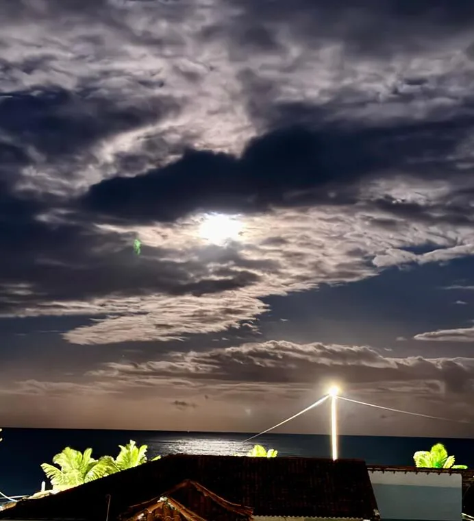 Lua entre nuvens iluminando o mar de Rio das Ostras em noite de luar