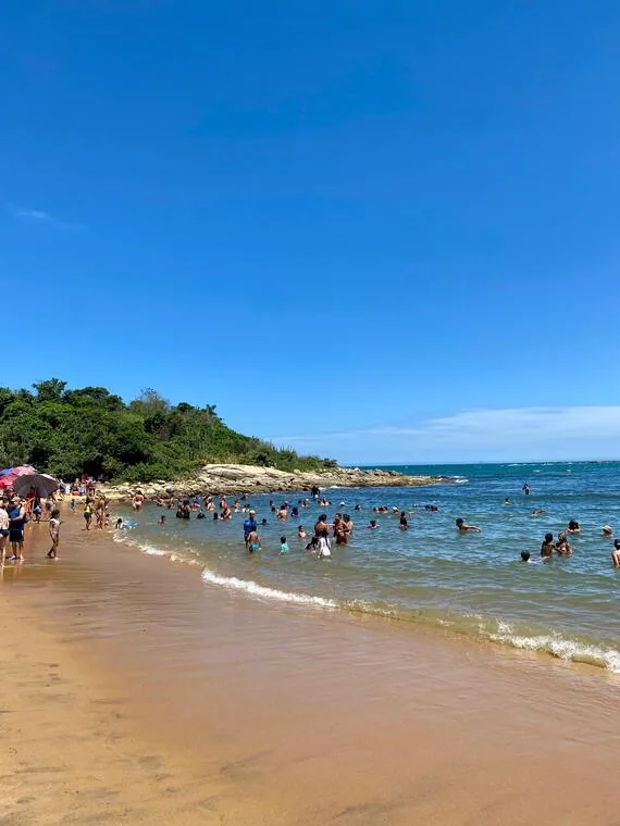 Banhistas aproveitando o mar em dia ensolarado numa praia de Rio das Ostras